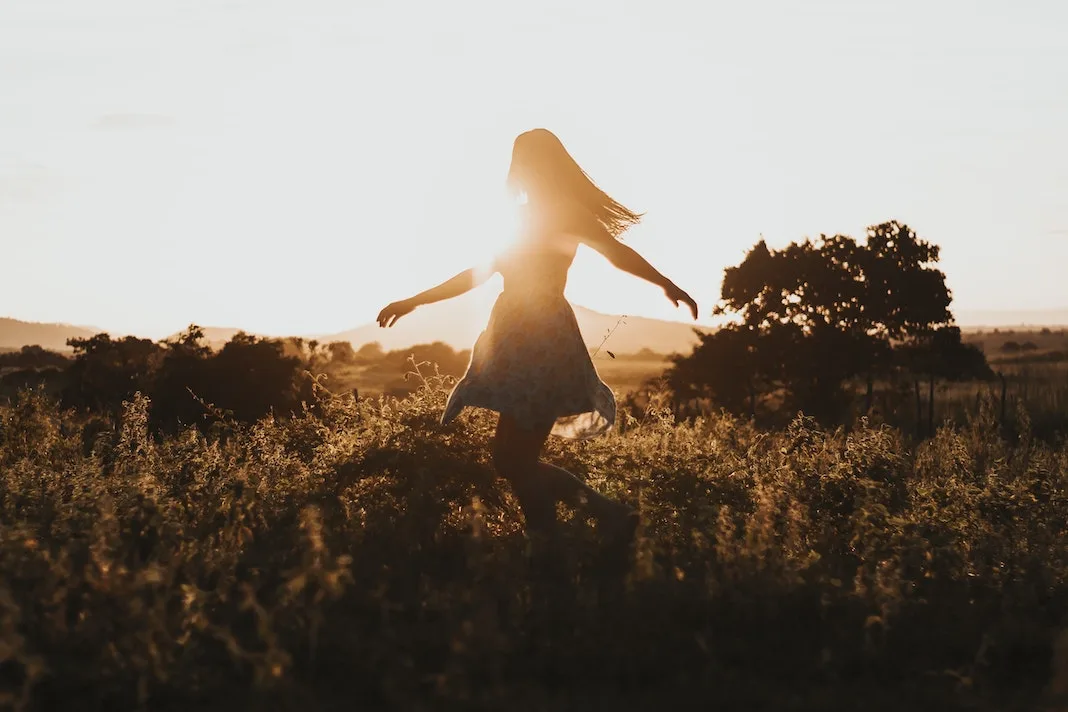 happy woman dancing in the flower fields